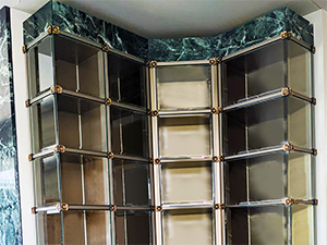 Interior glass front niches, indoor columbarium niches, custom design and custom built, granite, marble, strip lighting, in-house manufacturing and engineering, premium construction, elegant aesthetic, corner glass, curved glass, columbarium display for urns and memorabilia,