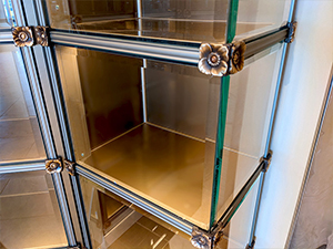 Interior glass front niches, indoor columbarium niches, custom design and custom built, granite, marble, strip lighting, in-house manufacturing and engineering, premium construction, elegant aesthetic, corner glass, curved glass, columbarium display for urns and memorabilia,